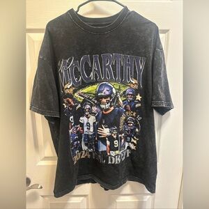 JJ McCarthy Minnesota Vikings Black Graphic T-Shirt with Football Design